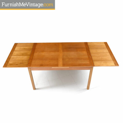 Ansager mid-century modern Danish teak draw leaf dining table. This table has two leaves at each end. Lift the table top and pull to extend the table top.