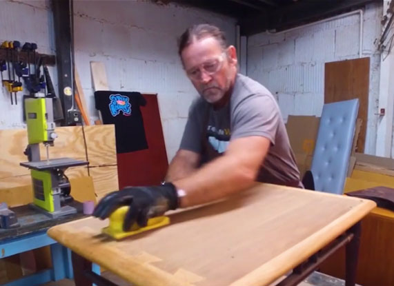 Man refinishing end table