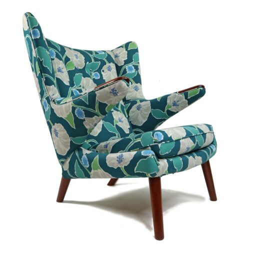 Iconic mid-century modern Papa Bear Chairs by Hans Wegner. The set comes with an ottoman as pictured and features floral teal, green and white fabric.