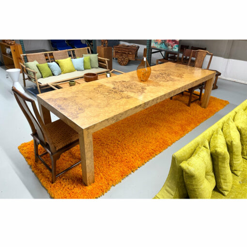 Orange Rya rug beneath burl dining table