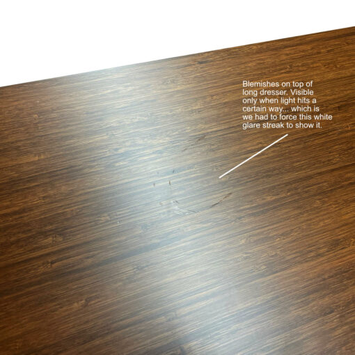 Blemish on top of long dresser only visible when light hits it a certain way. The white streak is light glare.