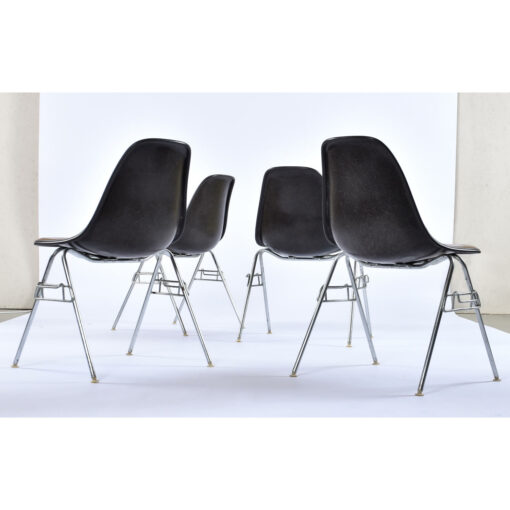 Back view of Charles Eames for Herman Miller black fiberglass shell chairs with brown Naugahyde seat pads